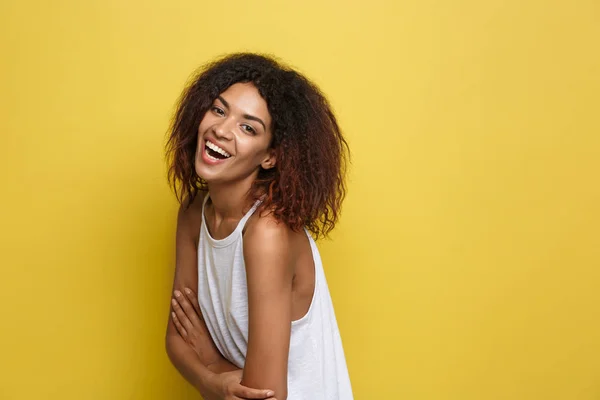 Headshot portret van mooie aantrekkelijke African American vrouw posten gekruiste armen met gelukkig lachend. Gele studio achtergrond. Kopiëren van ruimte — Stockfoto