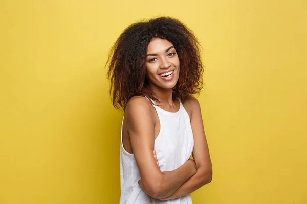 Headshot portret van mooie aantrekkelijke African American vrouw posten gekruiste armen met gelukkig lachend. Gele studio achtergrond. Kopiëren van ruimte — Stockfoto