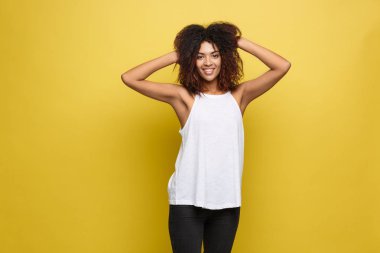 Onun kıvırcık afro saçlı güzel çekici Afrikalı-Amerikalı kadın deftere nakil oyun. Sarı stüdyo arka plan. Kopya alanı.