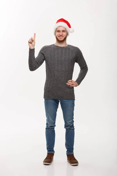 Concepto de vacaciones - Hombre joven barba en suéter disfrutar jugando y apuntando con el dedo hacia arriba. — Foto de Stock