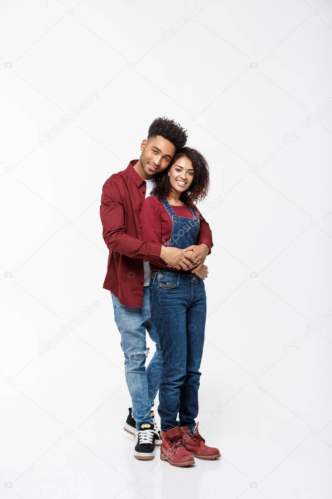 Full body portrait of young African American hugging couple, with smile. Dating, flirting, lovers, romantic studio concept, isolated on white background.