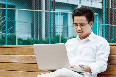 Genç işadamı Garden'da dizüstü bilgisayarda çalışma