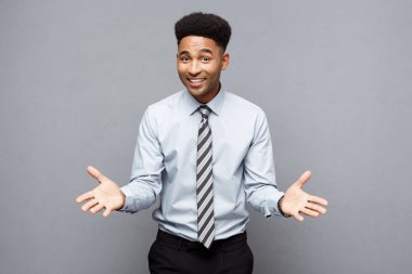 İş kavramı - gri arka plan üzerinde şaşırtıcı ifade ile onun önünde emin neşeli genç Afro-Amerikan gösteren el.