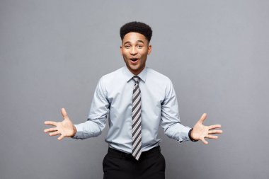 İş kavramı - gri arka plan üzerinde şaşırtıcı ifade ile onun önünde emin neşeli genç Afro-Amerikan gösteren el.