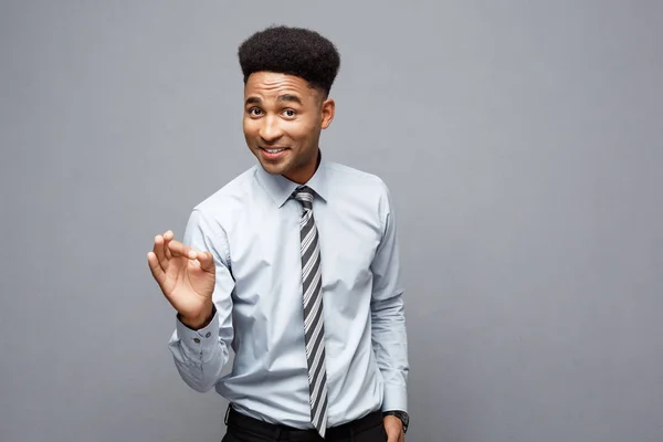 Businesskonzept - selbstbewusster, fröhlicher junger Afroamerikaner, der mit überraschendem Gesichtsausdruck vor grauem Hintergrund den Stinkefinger zeigt. — Stockfoto