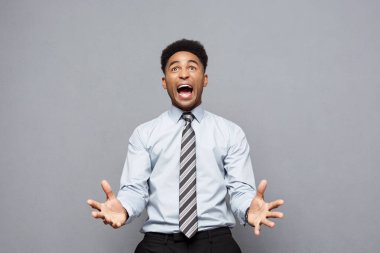 İş kavramı - gri arka plan üzerinde hayal kırıklığı ifade ile onun önünde emin neşeli genç Afro-Amerikan gösteren el.
