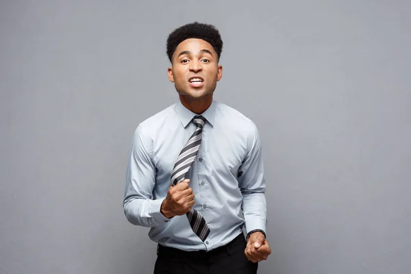 Geschäftskonzept - wütender Afroamerikaner mit verwirrtem Schreien mit frustriertem Gesichtsausdruck vor grauem Hintergrund. — Stockfoto