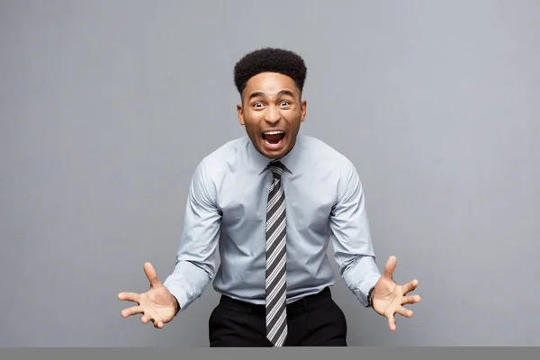 Geschäftskonzept - selbstbewusster, fröhlicher junger Afroamerikaner zeigt Hände vor ihm mit enttäuschtem Gesichtsausdruck vor grauem Hintergrund. — Stockfoto