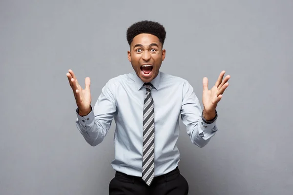 Concept d'entreprise - confiant jeune Afro-Américain joyeux montrant les mains devant lui avec expression déçue sur fond gris . — Photo
