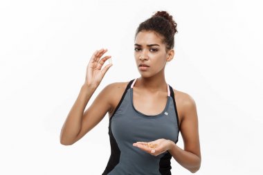 Sağlıklı ve Fitness kavramı - güzel Afrikalı-Amerikalı balık yağı hapı aldığın Closeup portresi. Beyaz stüdyo arka plan üzerinde izole.