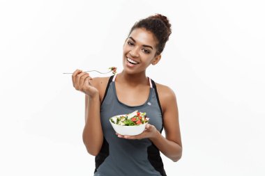 Sağlıklı ve Fitness kavramı - taze salata yemek diyet fitness giysili güzel Amerikan Afrika Bayan. Beyaz arka plan üzerinde izole.