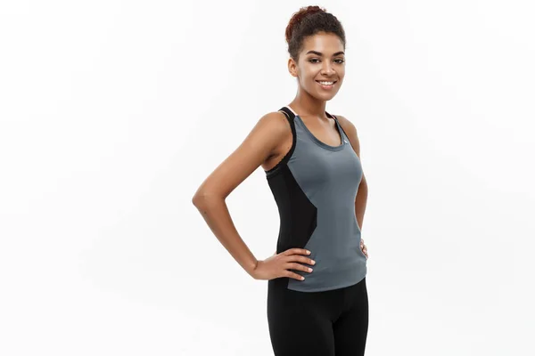 Здоровая и фитнес-концепция - красивая американская афроамериканка в спортивной одежде готова к тренировкам. Изолированный на белом фоне . — стоковое фото