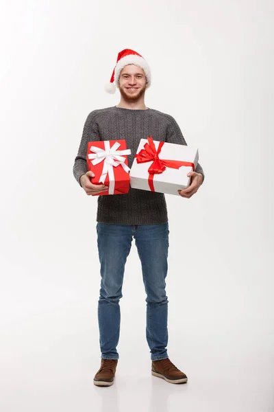 Christmas koncept - lycklig ung man med skägg bär en hel del presenter isolerad på vit bakgrund. — Stockfoto