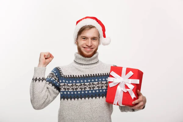 Boże Narodzenie koncepcja - szczęśliwy młody człowiek z brodą, trzymając obecny i ręka w górę na białym tle. — Zdjęcie stockowe