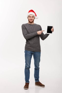 Tatil ve İş Konsepti - Tablet ekranı gösteren ve işaret eden genç yakışıklı adam.