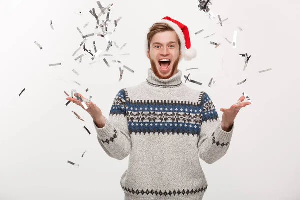 Chirstmas concept - glücklicher junger Mann mit kaukasischem Bart, der Konfetti zum Weihnachtsfest wirft. — Stockfoto