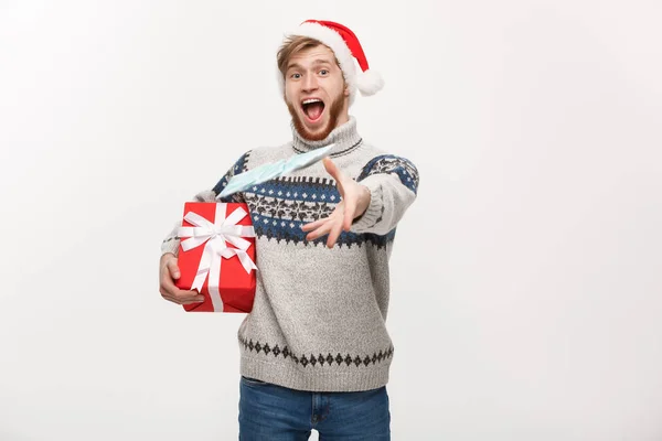 Urlaubskonzept - junger Mann mit Bart hält Weihnachtsgeschenk in der Hand und wirft Geld in die Kamera. — Stockfoto