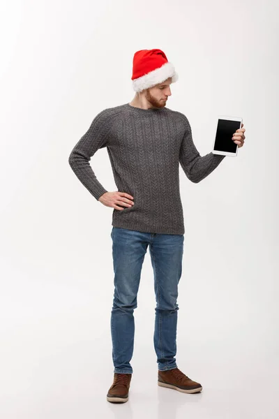 Holiday and Business Concept - молодий красивий чоловік дивиться і показує дисплей планшетів для презентації . — стокове фото
