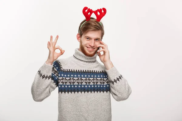 Holiday and Business Concept - Joven hombre guapo hablando por teléfono y dando señal de ok . —  Fotos de Stock