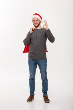 Noel kavramı - kırmızı büyük santa ihale ve ok işareti veren genç emin akıllı adam.