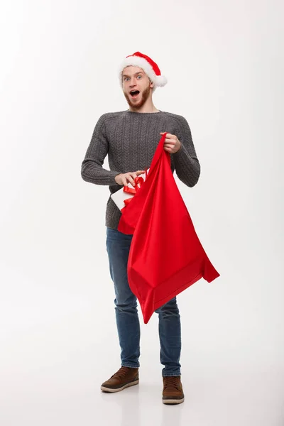 Conceito de Natal - Jovem homem barba feliz excitar com grande presente em santa bolsa . — Fotografia de Stock