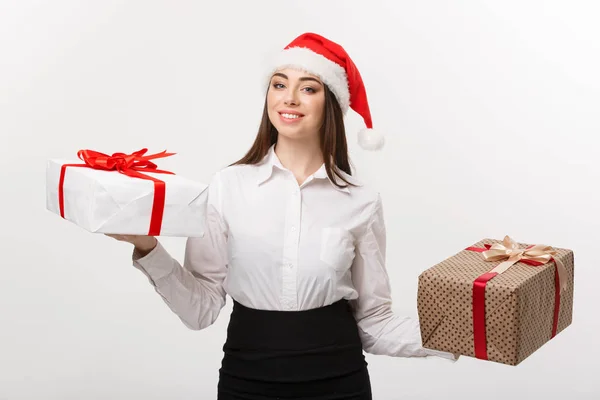 Conceito de Natal - jovem mulher de negócios caucasiana feliz com chapéu de Papai Noel escolher caixas de presente com espaço de cópia no lado . — Fotografia de Stock