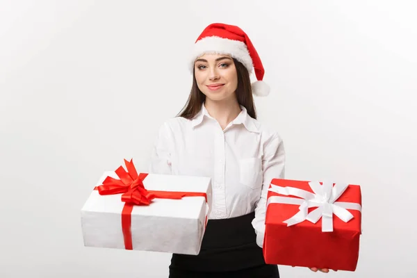 Conceito de Natal - jovem mulher de negócios caucasiana feliz com chapéu de Papai Noel dando uma escolha de caixas de presente para câmera com espaço de cópia no lado . — Fotografia de Stock