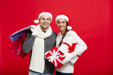 Noel kavramı - alışveriş çantası tutan genç çekici çift alışveriş ve Noel günü kutlamanın keyfini çıkarın