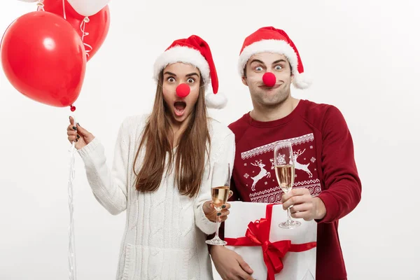 圣诞概念-年轻的白种情侣举行礼物, 香槟和气球在圣诞节滑稽的面孔 — 图库照片