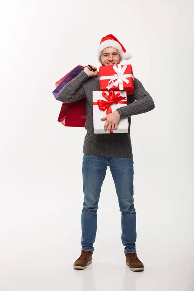 Christmas koncept - attraktiv ung kaukasiska man shoppa håller en hel del julklappar på juldagen. — Stockfoto