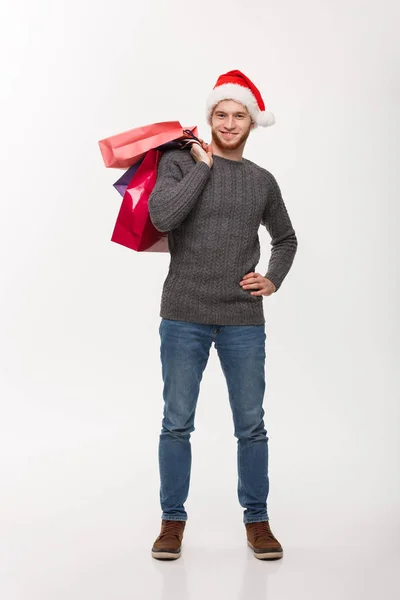 Concepto de Navidad - Joven barba guapo hombre feliz con el bolso de la compra en la mano aislado en blanco . — Foto de Stock