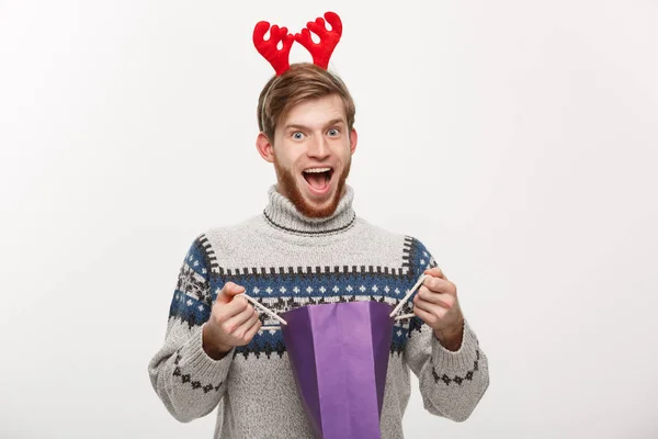 Concepto de Navidad - Joven barba guapo hombre feliz con el bolso de la compra en la mano aislado en blanco . — Foto de Stock