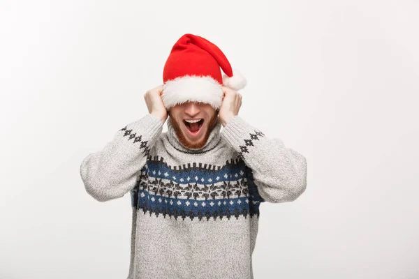 Urlaubskonzept - Junger Bartträger im Pullover spielt gern mit Weihnachtsmütze. — Stockfoto