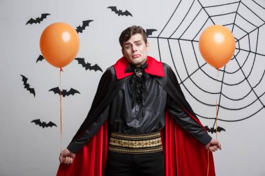 Vampir halloween kostüm yakışıklı beyaz renkli balon ile portresi.
