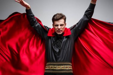 Vampir Cadılar Bayramı kavramı - yakışıklı beyaz vampir halloween kılık kırmızı, siyah hırkasını çırpınan portresi.