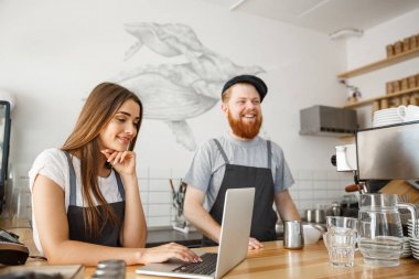 Kahve iş kavramı - mutlu genç çift işletme sahipleri küçük coffee shop çalışma ve dizüstü bilgisayarda planya.