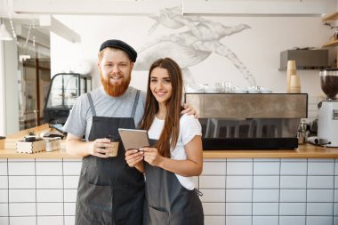 Kahve iş kavramı - mutlu genç çift işletme sahipleri küçük coffee shop çalışma ve tablete planya.