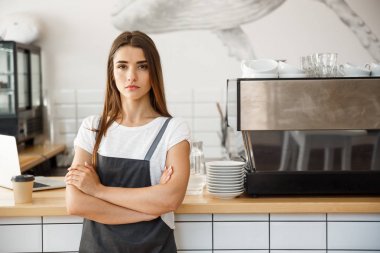 Kahve iş sahibi kavramı - mutlu çekici genç güzel beyaz barista kahve dükkanı sayaç kamerada kendine güvenen bakarak ile önlük portresi.