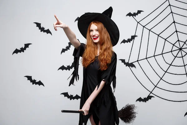 Halloween Concept - Happy elegante heks genieten van het spelen met bezemsteel. — Stockfoto