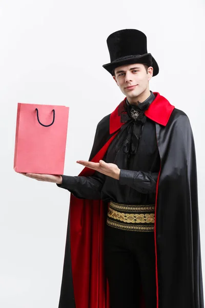 Vampir Cadılar Bayramı kavramı - mutlu yakışıklı beyaz vampir holding renkli alışveriş çantası beyaz arka plan üzerinde. — Stok fotoğraf