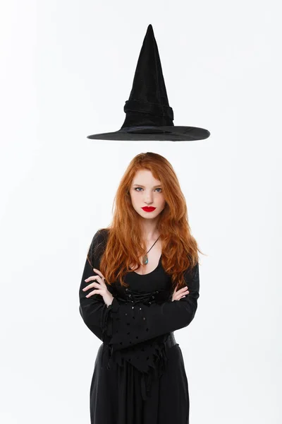 Concept de sorcière Halloween Joyeux Halloween Cheveux gingembre sexy Sorcière avec chapeau magique volant au-dessus de sa tête. Isolé sur fond blanc . — Photo