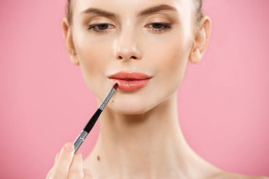 Güzellik kavramı - pembe Studio arka plan üzerinde poz uzun saç ve kırmızı dudaklı beyaz kadın mutlu moda. 