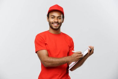 Teslimat kavramı - portre yakışıklı African American teslimat adam ya da kurye yazma bir siparişi belge üzerinde. Arka plan gri studio izole. Kopya alanı.