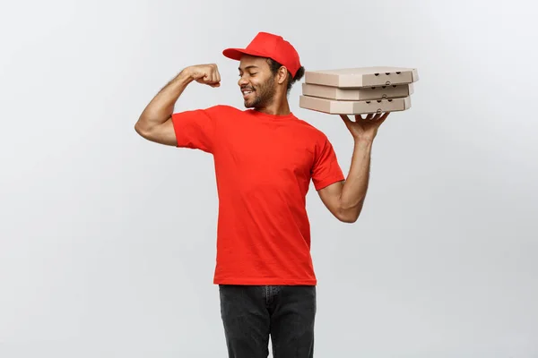 Conceito de entrega - Retrato de homem de entrega afro-americano forte mostrando seu músculo com pacotes de caixa de pizza. Isolado no estúdio Grey Background. Espaço de cópia . — Fotografia de Stock