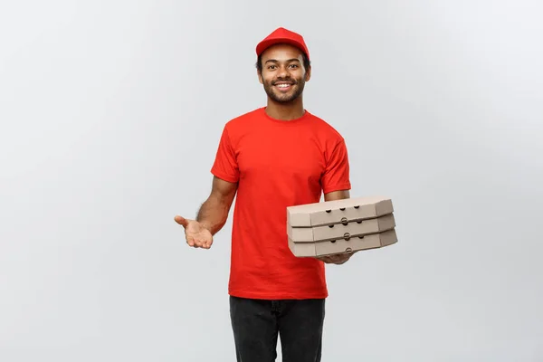 Concetto di consegna Ritratto di bello afroamericano Pizza uomo di consegna. Isolato su sfondo grigio studio. Copia spazio. — Foto Stock