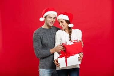 Noel kavramı - yakışıklı genç erkek arkadaşı Noel kazağı sürpriz hediyeler ile kız arkadaşı