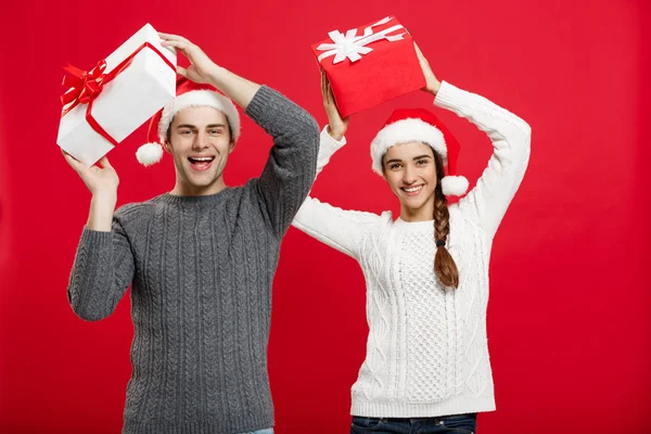 Conceito de Natal - retrato jovem casal em camisola de Natal gosta de brincar com presentes — Fotografia de Stock