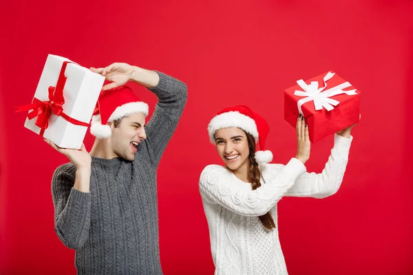 Conceito de Natal - retrato jovem casal em camisola de Natal gosta de brincar com presentes — Fotografia de Stock