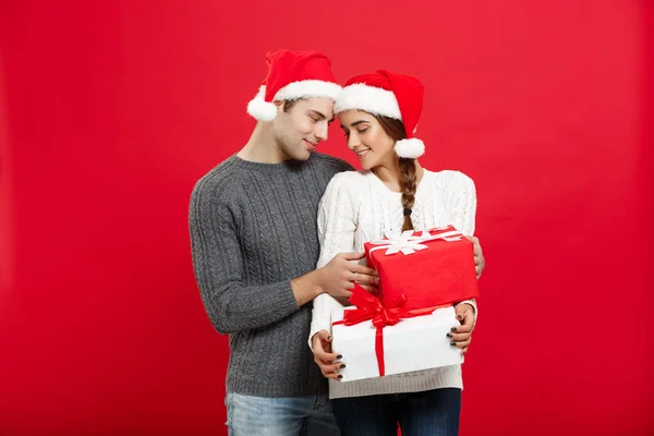 Conceito de Natal - bonito namorado jovem em camisola de Natal surpreender sua namorada com presentes — Fotografia de Stock