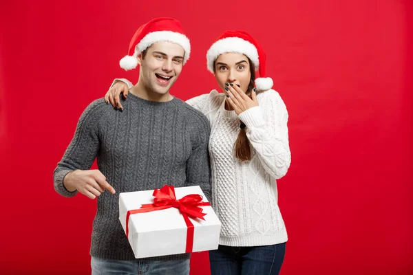 Conceito de Natal - retrato jovem casal em camisola de Natal apontando gesto dedo para presentes — Fotografia de Stock